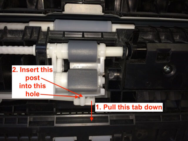 Pull the tab down and insert the roller assembly post into the hole