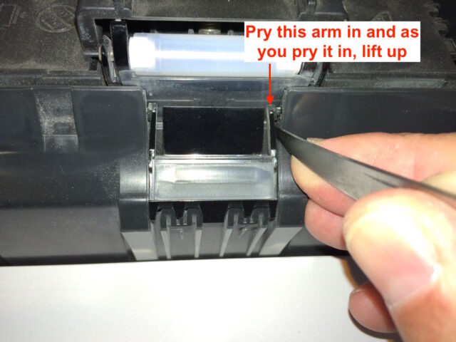 Pry the right arm in, up, and out of the paper tray body