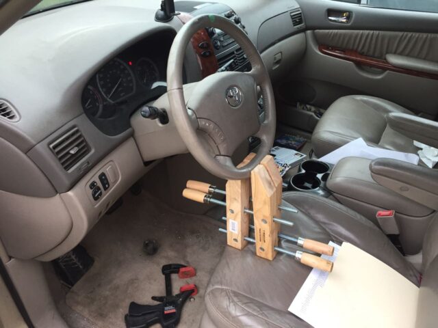 Using clamps, wedged against the seat, to hold the steering wheel straight