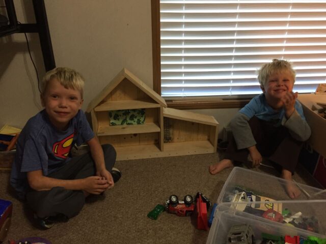 Boys posing with the doll house.