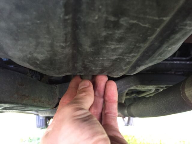 Unscrewing the drain plug by hand